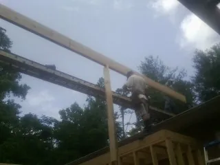 Carpenter setting a ridge beam over a new addition frame — Ice Dam Removal by Roofing Brothers in Huntington Woods