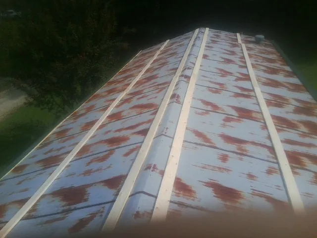 Rusted metal roof panels with new wood purlins before replacement — Storm Damage Roof Repair in Huntington Woods by Roofing Brothers