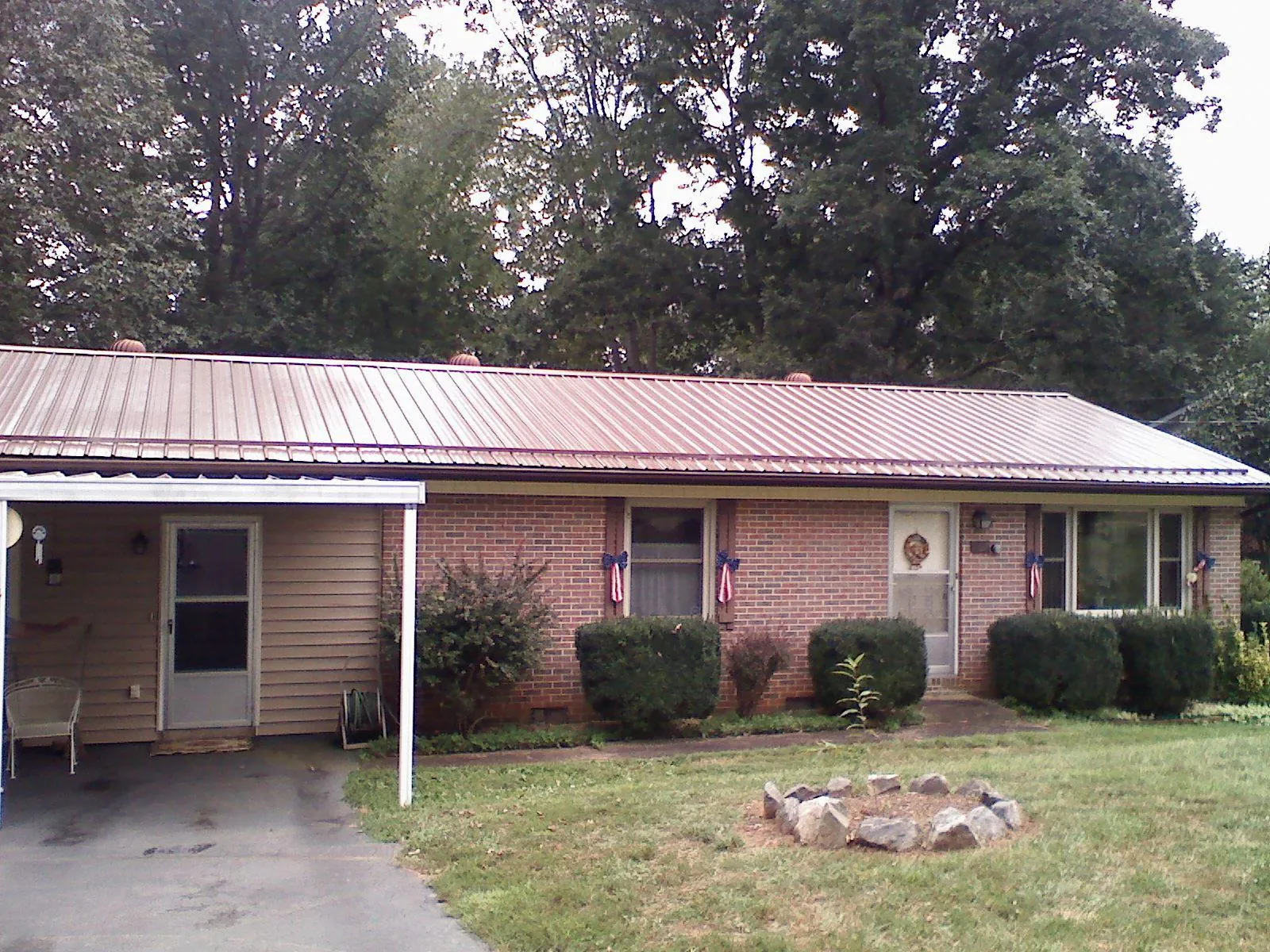 Bronze metal roof and carport on a brick ranch home — Roof Repair work by our crew in Huntington Woods